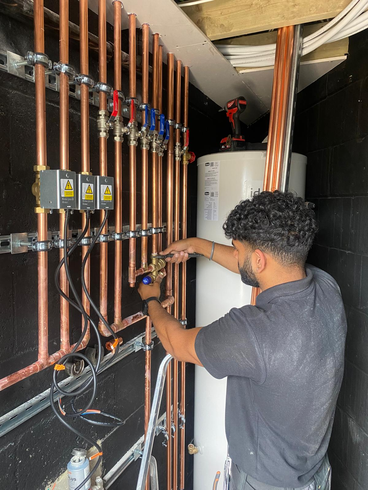 Professional engineer installing copper piping for heating system